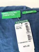 Load image into Gallery viewer, Close-up of a blue denim garment showing a green United Colors of Benetton label, a green Pure Linen tag, and a white Simons retail price tag.