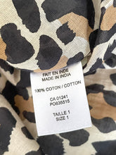 Load image into Gallery viewer, Close-up of a leopard-print garment tag with French text reading 'FAIT EN INDIE MADE IN INDIA', '100% COTON / COTTON', and size information, set against matching beige, black, and brown animal-print fabric.