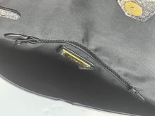 Load image into Gallery viewer, Close-up of a black fabric bag interior showing a black zipper with a gold-tone metal pull tab and a small gold logo plate that appears to read 'BLOOM'.