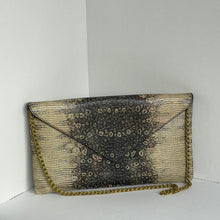 Load image into Gallery viewer, A rectangular clutch bag with a textured black and beige animal print, featuring a gold chain strap, photographed against a plain white background.