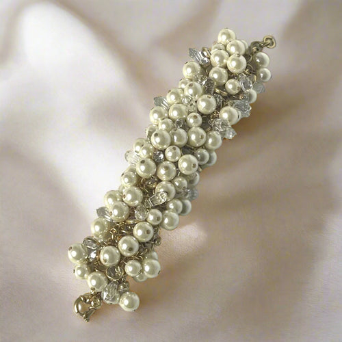 Pearl bracelet with clear crystals on a light gray background