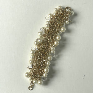 Gold and pearl bracelet on a light gray background