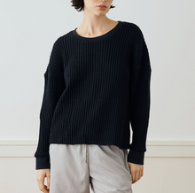 Load image into Gallery viewer, Person wearing a black ribbed sweater and light gray pants on a white background