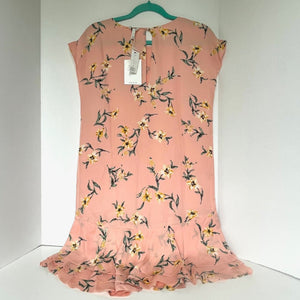 Pink floral dress on a hanger against a white background