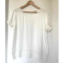 Load image into Gallery viewer, White blouse with lace details on a hanger against a plain background