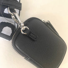 Load image into Gallery viewer, Black textured pouch with silver zipper and strap on a light beige background