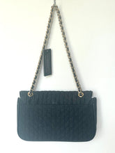 Load image into Gallery viewer, A black quilted shoulder bag with a gold-tone chain strap and a hanging tag, photographed against a plain white wall.