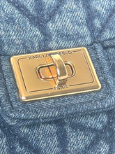 Load image into Gallery viewer, Close-up of a Karl Lagerfeld Paris metal clasp on a blue quilted fabric surface.