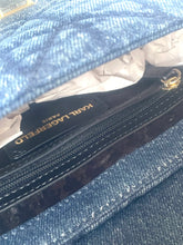 Load image into Gallery viewer, Close-up of a blue denim handbag with a black zipper pocket featuring a Karl Lagerfeld Paris label and gold hardware.
