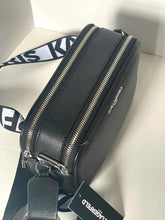 Load image into Gallery viewer, Black crossbody bag with visible brand tag on a neutral background