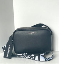 Load image into Gallery viewer, Black handbag with a visible brand tag on a white background
