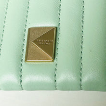 Load image into Gallery viewer, Close-up of a light green leather product with a gold logo, featuring 'kate spade new york'.