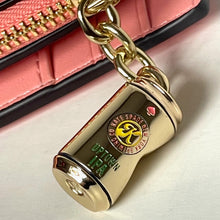 Load image into Gallery viewer, Gold padlock charm with brand logo on a pink textured background