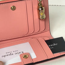 Load image into Gallery viewer, Pink wallet with gold accents and a visible brand tag on a white background