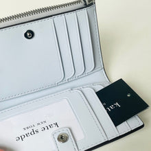 Load image into Gallery viewer, Light blue wallet with 'Kate Spade' branding on a white background