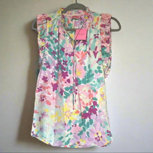 Colorful floral dress on a hanger against a white background