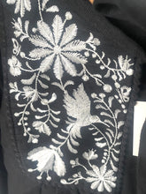 Load image into Gallery viewer, Embroidered design on a black fabric with white floral and bird patterns.