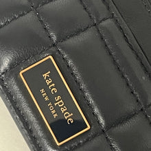 Load image into Gallery viewer, Close-up of a black quilted handbag with &#39;kate spade New York&#39; logo.