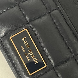 Close-up of a black quilted handbag with 'kate spade New York' logo.
