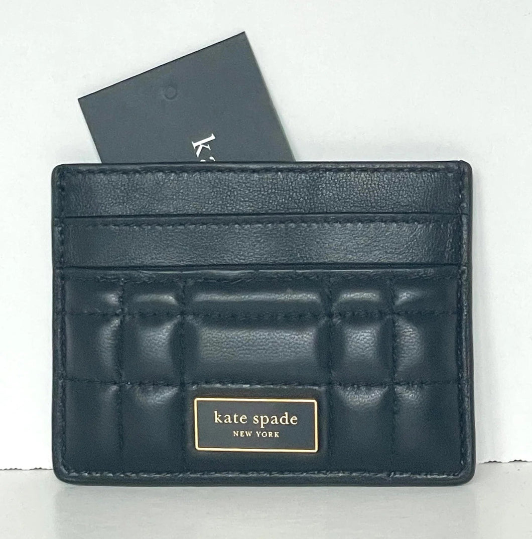 Black quilted cardholder with 'kate spade New York' branding on a white background