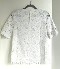 Load image into Gallery viewer, White lace top on a hanger against a white wall