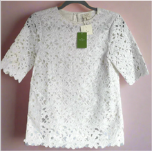 Load image into Gallery viewer, White lace top on a hanger with a pink background