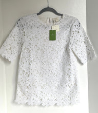 Load image into Gallery viewer, White lace top on a hanger with a visible tag against a white background