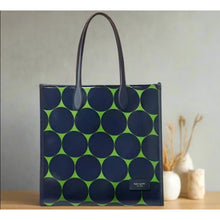 Load image into Gallery viewer, Blue tote bag with green circle pattern on a wooden surface with decorative items.