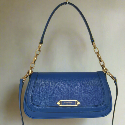 Blue handbag with gold chain strap on a blurred background