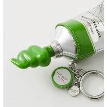 Load image into Gallery viewer, Green and silver keychain with 'kate spade' branding on a white background