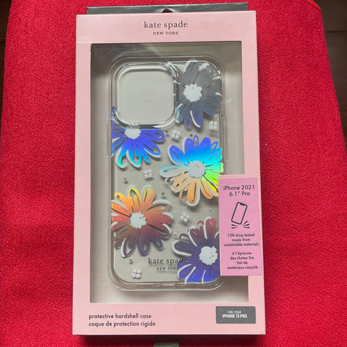 Kate Spade phone case packaging with colorful flowers on a red surface