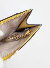 Load image into Gallery viewer, Close-up of an open zippered wallet or card holder with a gold-tone chain key ring, showing a beige patterned interior and a yellow-gold inner flap on a white background.
