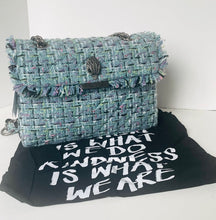 Load image into Gallery viewer, Blue textured handbag on a black mat with white text