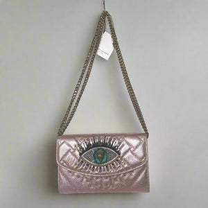Metallic pink handbag with eye design and chain strap on a white background