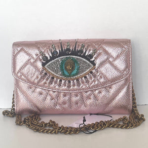 Rose gold handbag with eye design and chain strap on a white background