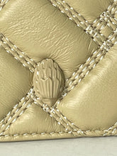Load image into Gallery viewer, Close-up of a quilted beige leather bag with diagonal stitching and a central sculptural bead detail.
