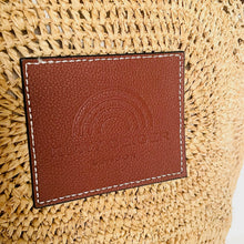 Load image into Gallery viewer, Brown leather patch with embossed logo on a woven surface