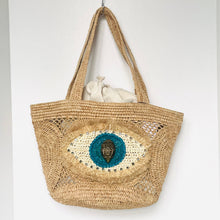 Load image into Gallery viewer, Woven bag with eye design and handle on a white background