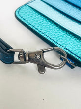 Load image into Gallery viewer, Close-up of a metallic turquoise card holder or wallet with a dark blue strap and a silver metal lobster clasp, on a white background.