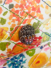 Load image into Gallery viewer, Decorative button with gemstones on a colorful floral fabric background