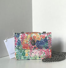 Load image into Gallery viewer, Multicolored floral-patterned handbag with a chain strap on a light gray surface.