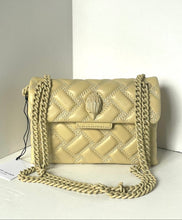 Load image into Gallery viewer, Beige quilted handbag with chain strap on a white surface