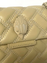 Load image into Gallery viewer, Beige quilted handbag with a decorative clasp on a matching background