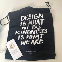 Load image into Gallery viewer, Black drawstring bag with white text and a visible brand tag on a light background