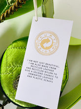 Load image into Gallery viewer, Green bag with a white tag featuring Kurt Geiger branding and sustainability information.