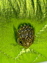 Load image into Gallery viewer, Decorative button with intricate design on a green textured background