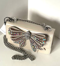 Load image into Gallery viewer, Silver clutch bag with a large bow embellishment on a light background