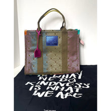 Load image into Gallery viewer, Tote bag with geometric pattern and text on a black surface