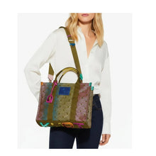 Load image into Gallery viewer, Woman holding a colorful handbag with a white background