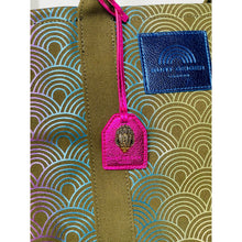 Load image into Gallery viewer, Close-up of a green fabric with pink tag and blue label on a white background